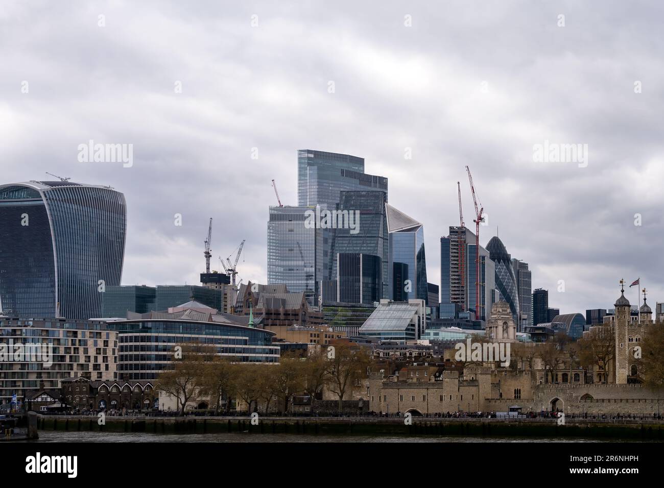 LONDON, ENGLAND - APRIL 18th, 2023: View of the Tower of London and the skyscrapers of City of London behind it on a cloudy spring day Stock Photo
