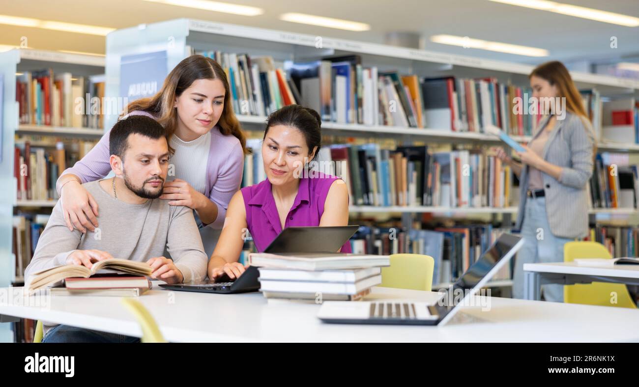 Female and male colleagues working together in public library Stock ...