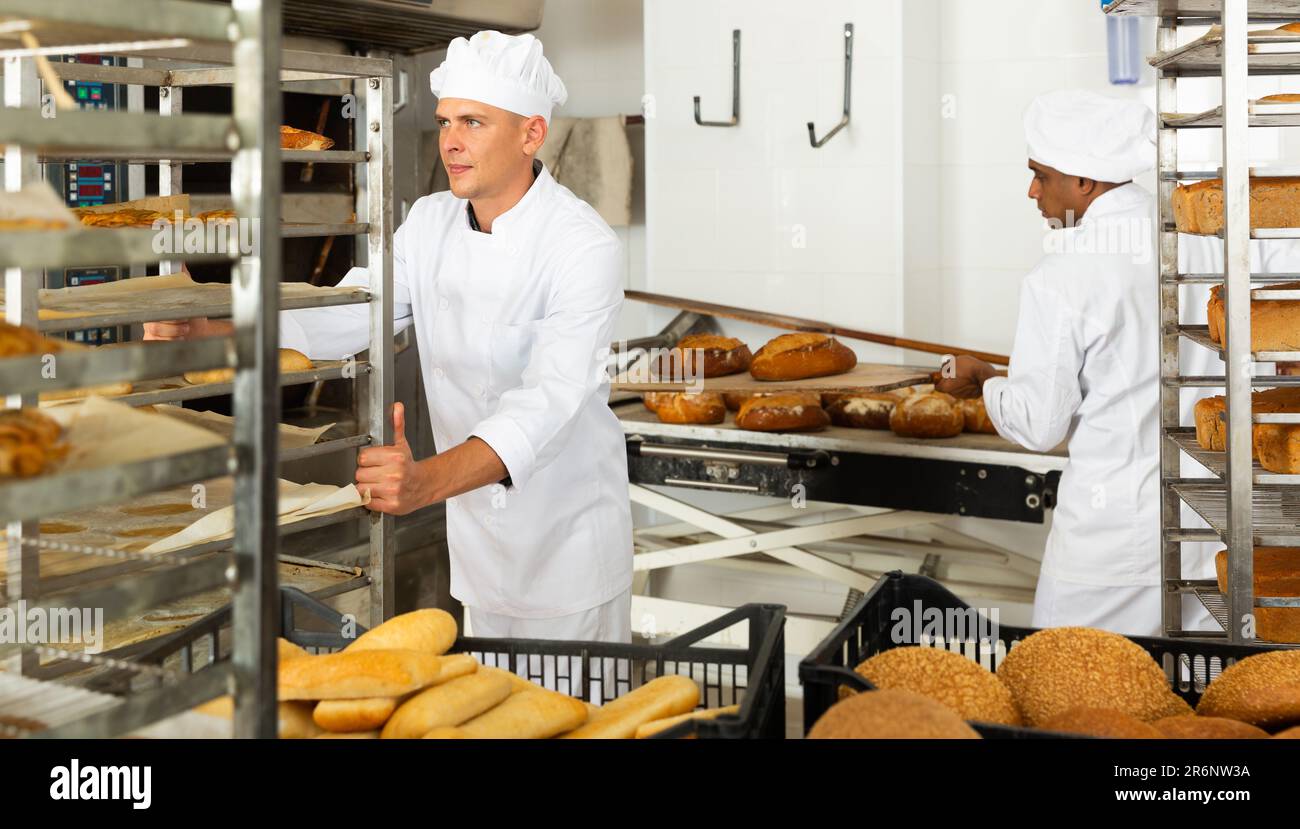 Man transporting cart with bread in bakery Stock Photo - Alamy