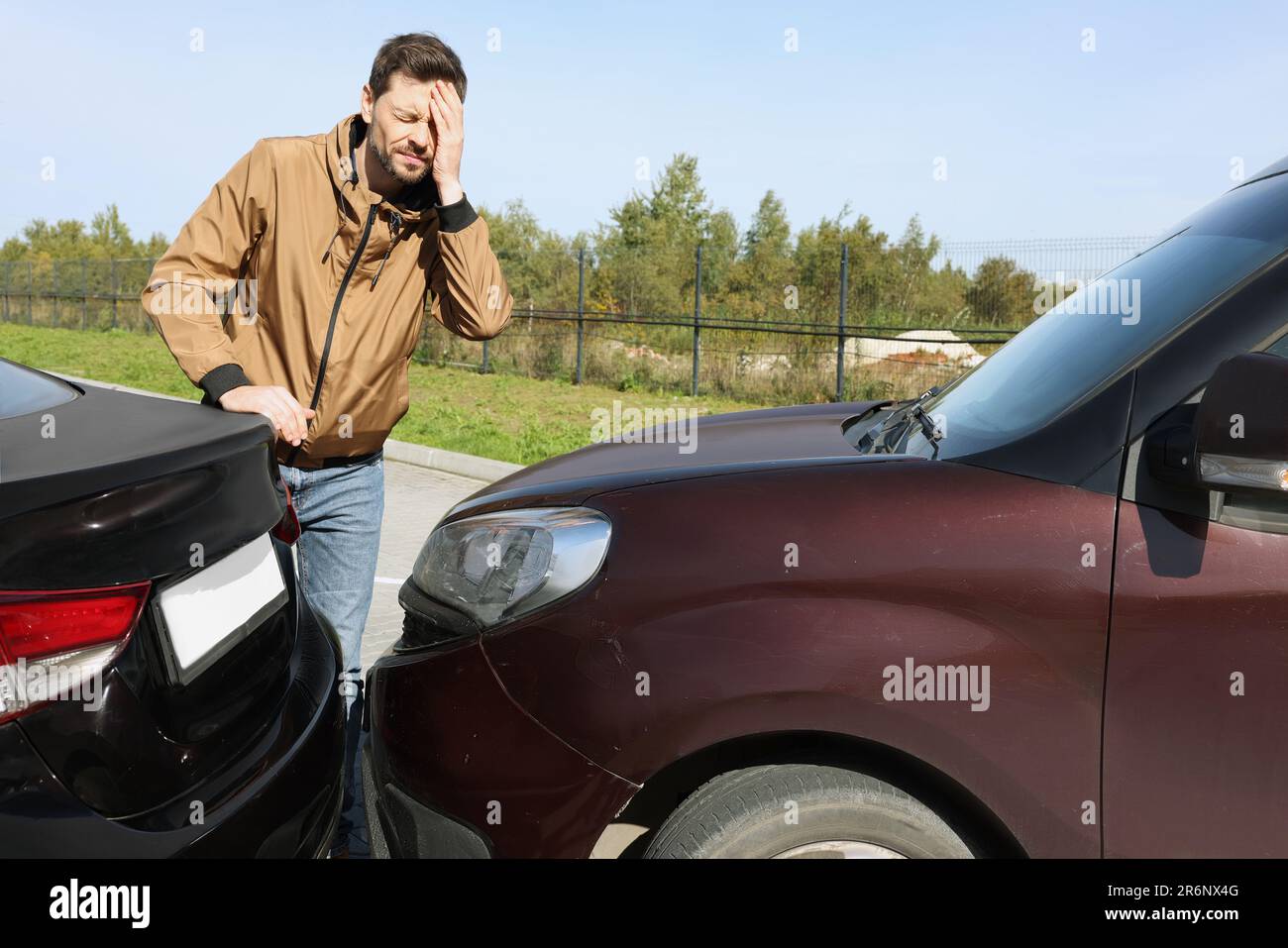 Stressed man near car with scratch outdoors. Auto accident Stock Photo