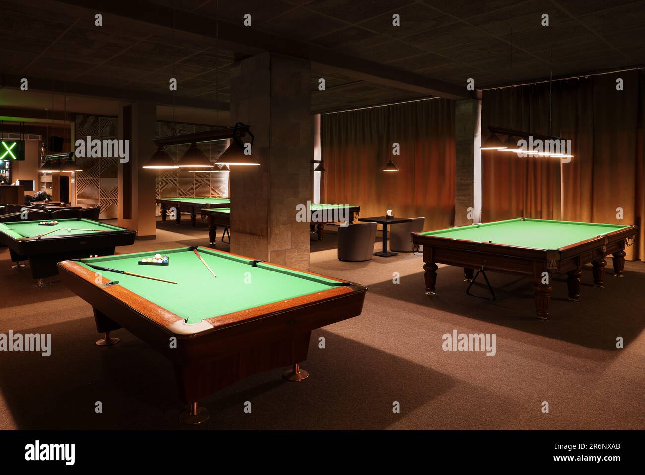 Billiard tables with balls and cues in club Stock Photo