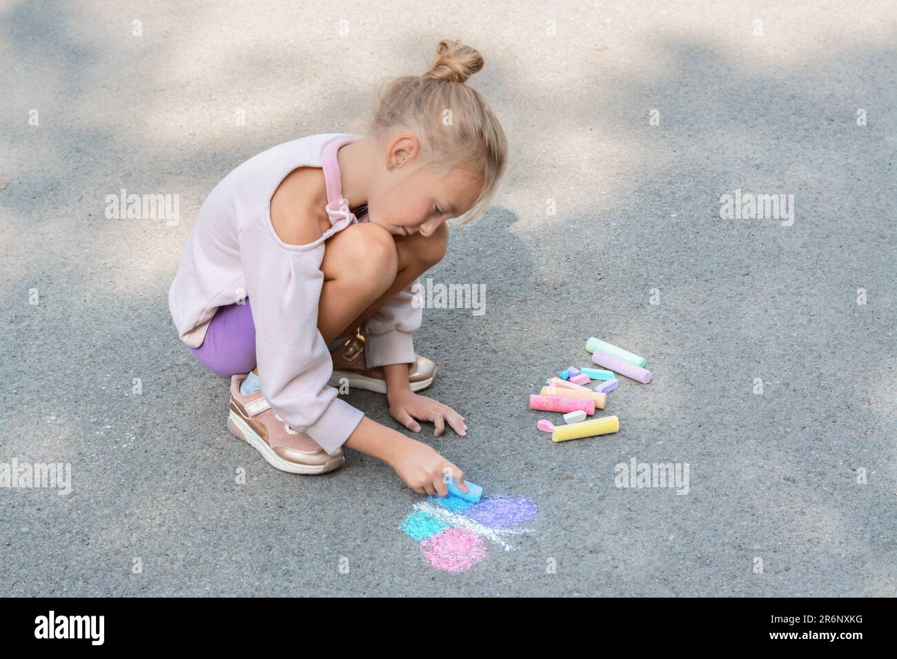 Little child drawing butterfly with chalk on asphalt Stock Photo - Alamy