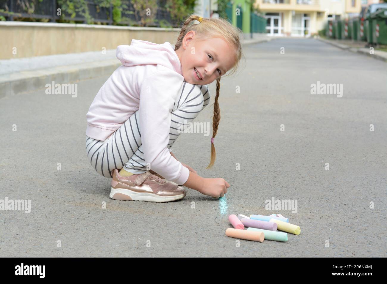 Little child drawing happy family with chalk on asphalt Stock Photo - Alamy