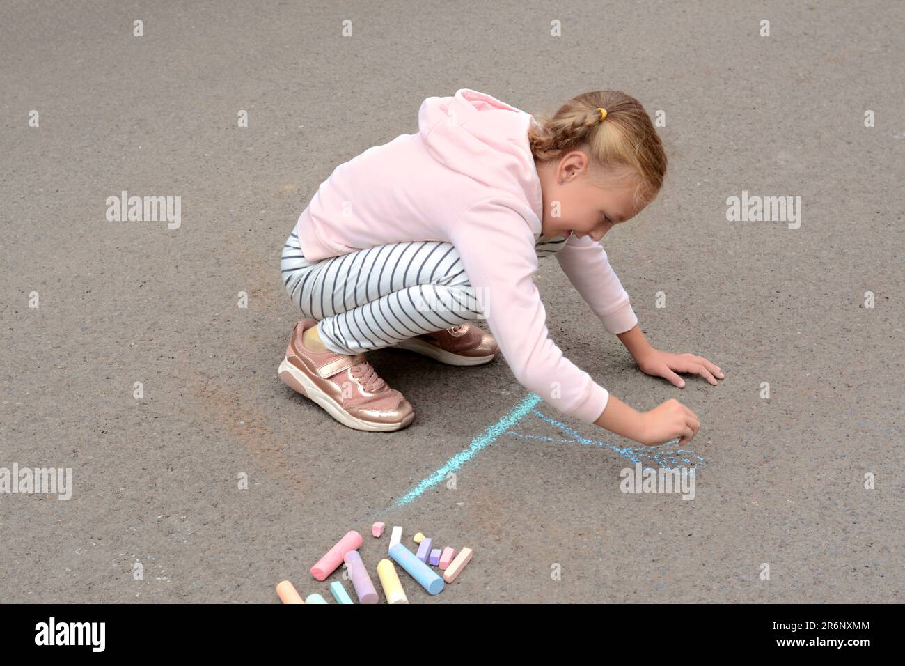 Little child drawing happy family with chalk on asphalt Stock Photo - Alamy