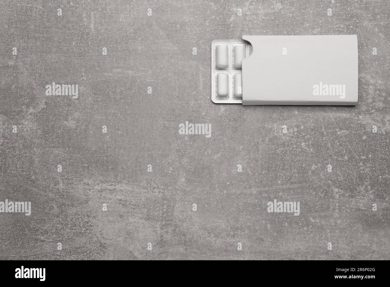 Blister with chewing gums on light grey table, top view. Space for text