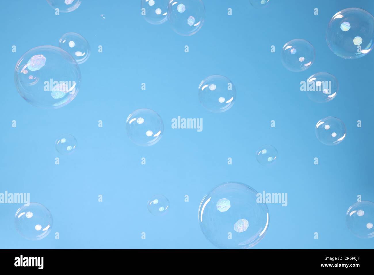 Many beautiful soap bubbles on light blue background Stock Photo - Alamy