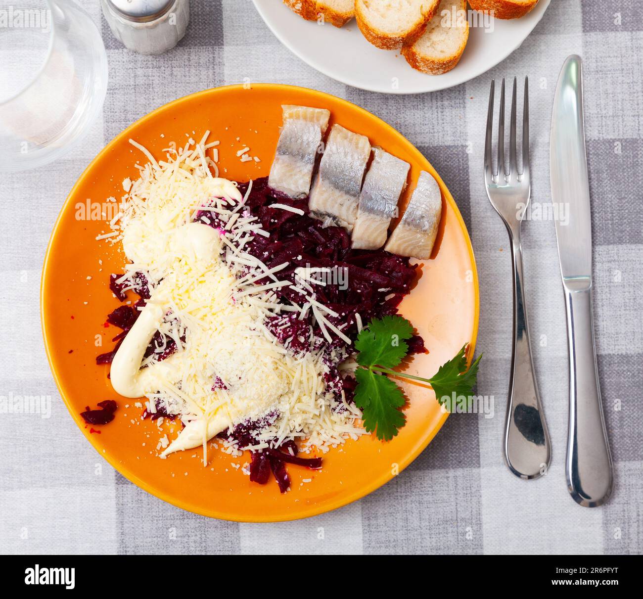Sliced herring with grated beetroot and cheese served on table Stock Photo