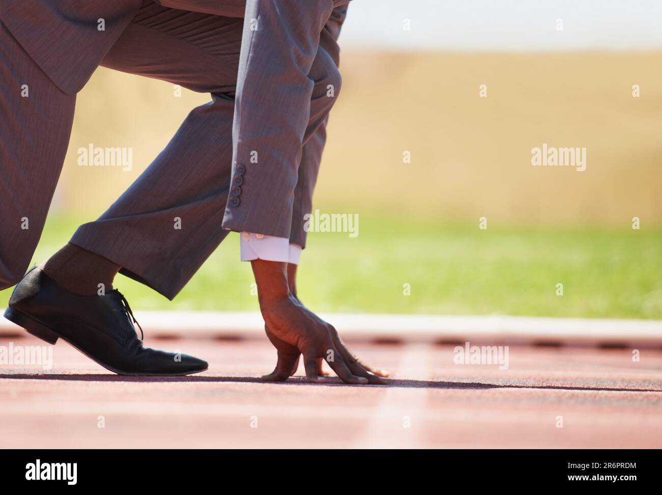 Race track, start and man in a suit for sport, running and fitness, cardio and speed practice. Starting line, ready and formal male sports runner at a Stock Photo