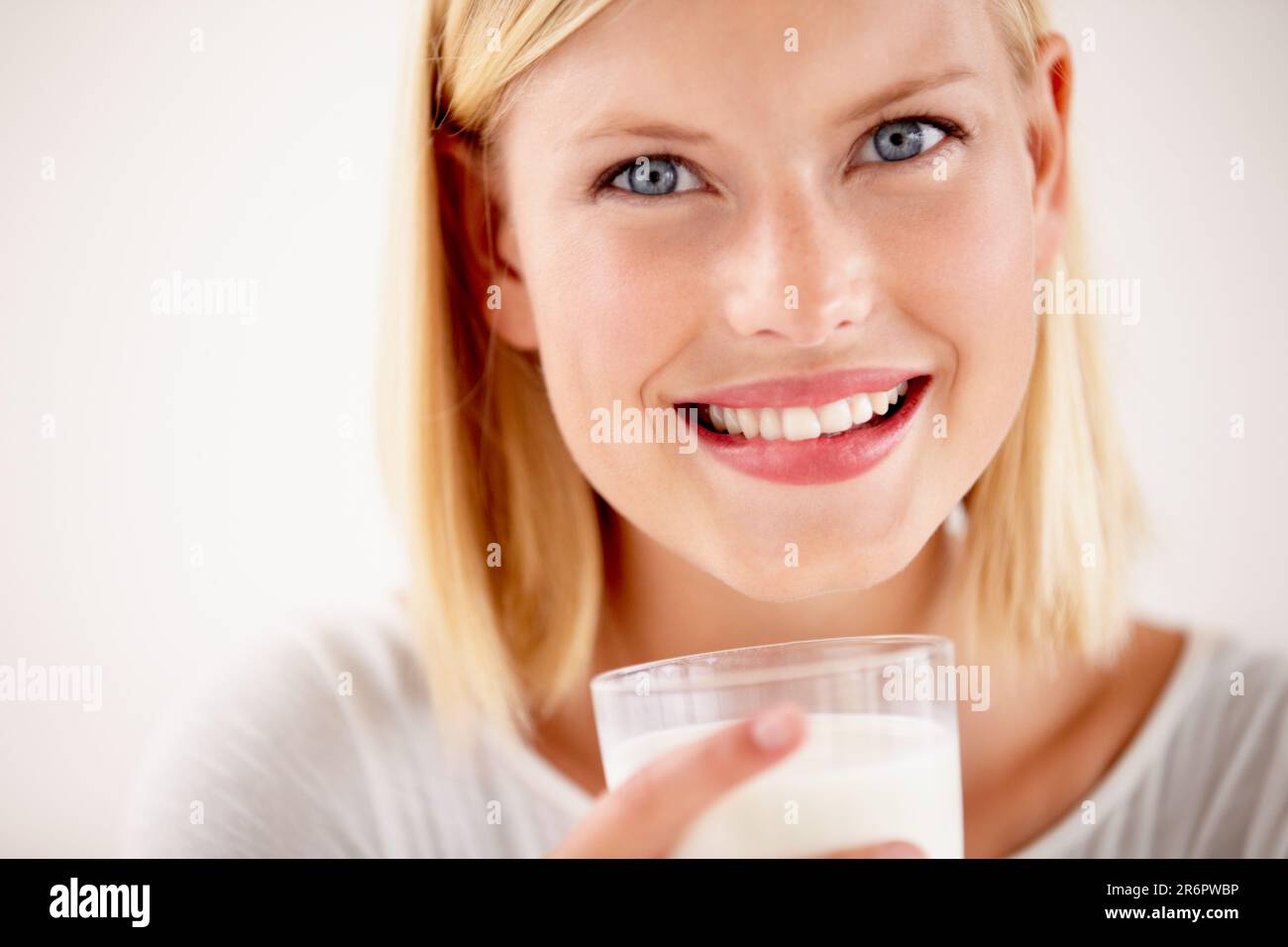Dairy, woman drinking a glass of milk and in a white background with a