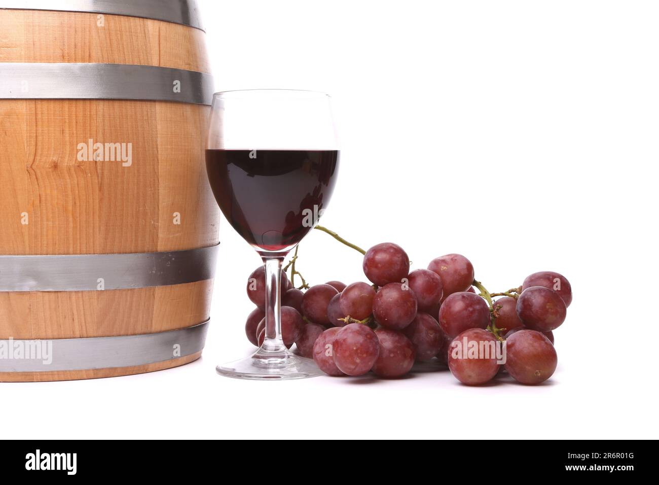 A glass of red wine with grapes and barrel on the white background. Stock Photo