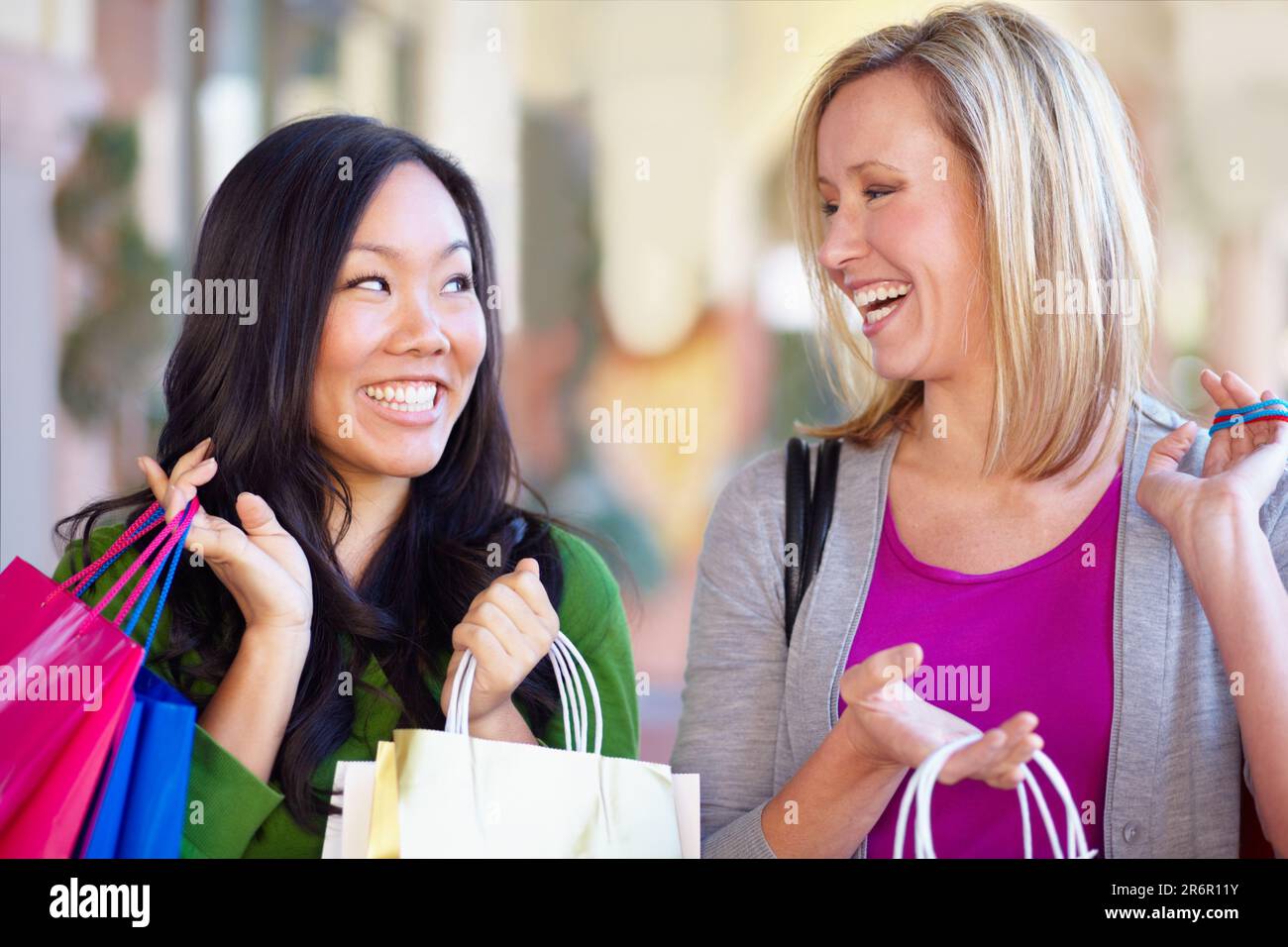Happy, sale and women with bags from shopping in the city or mall and excited about a deal. Smile, conversation and diversity with female friends Stock Photo