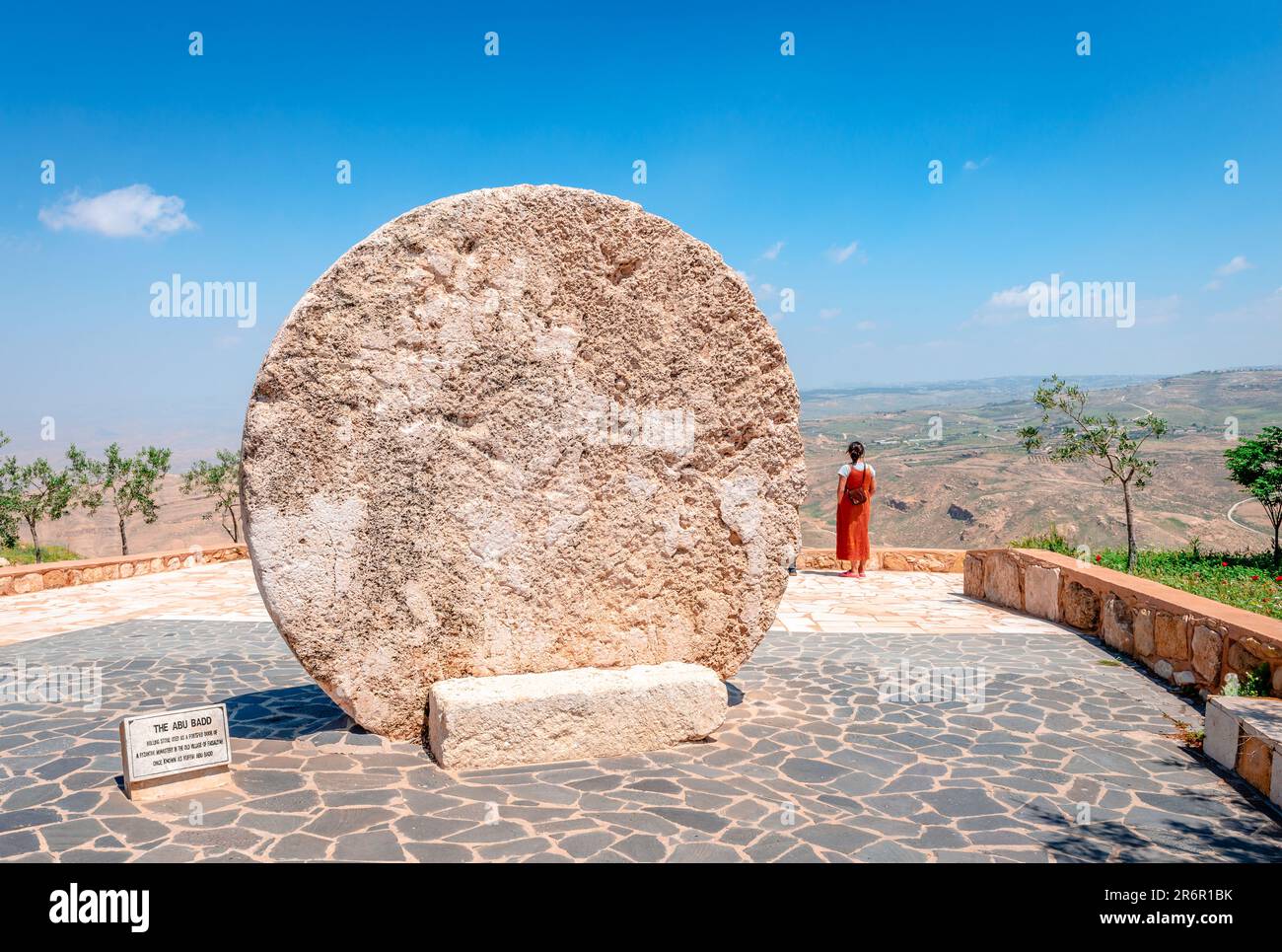 The Abu Badd, a rolling stone used as a fortified door of a Byzantine monastery in the old village of Faisaliyah. Unidentified woman enjoying the view Stock Photo
