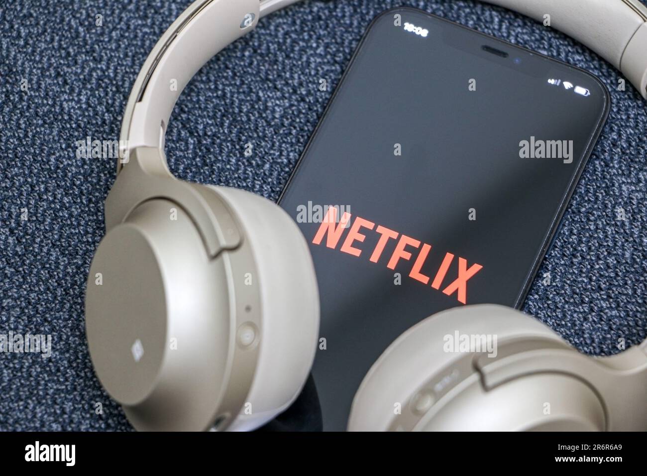 Netflix on smartphone, Netflix logo displayed on screen, gold