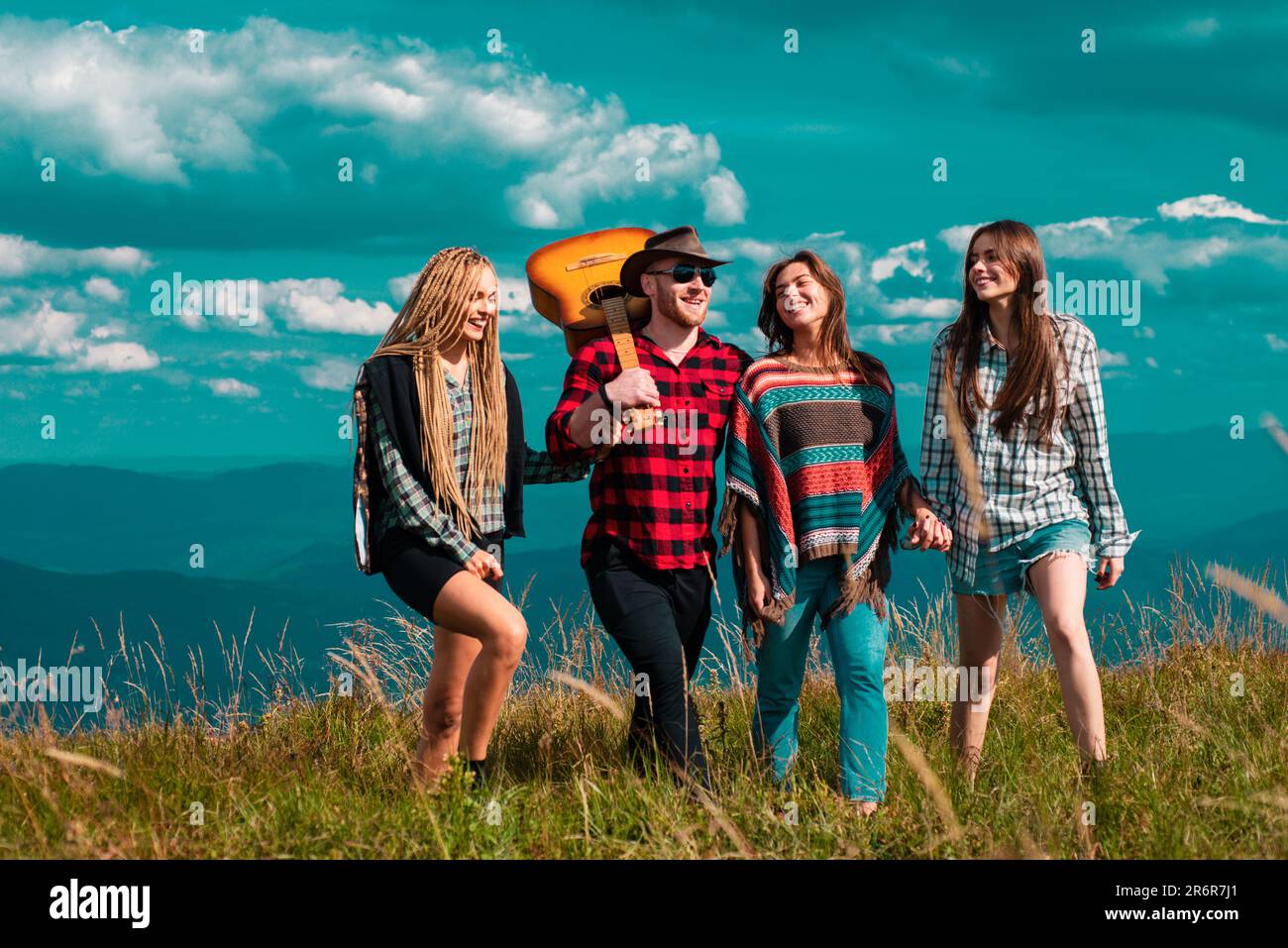 Group of friends on country walk on a summer day. Young people hiking