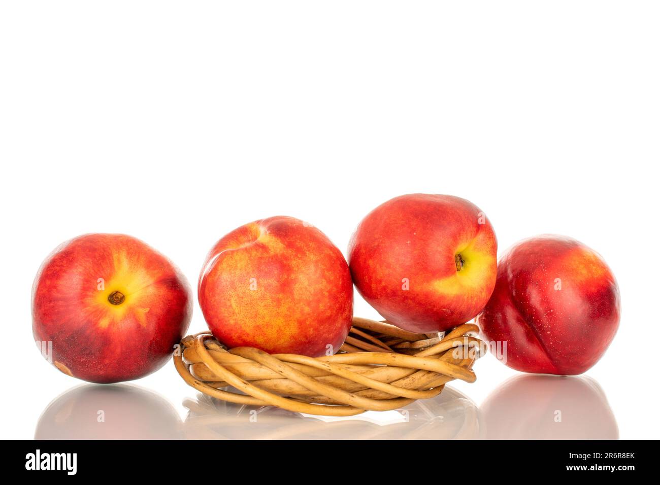 Four sweet nectarines with vine wreath, macro, isolated on white