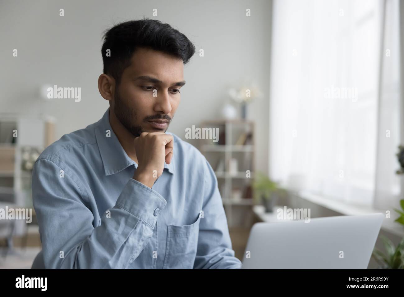 Focused handsome young Indian professional man working at computer Stock Photo