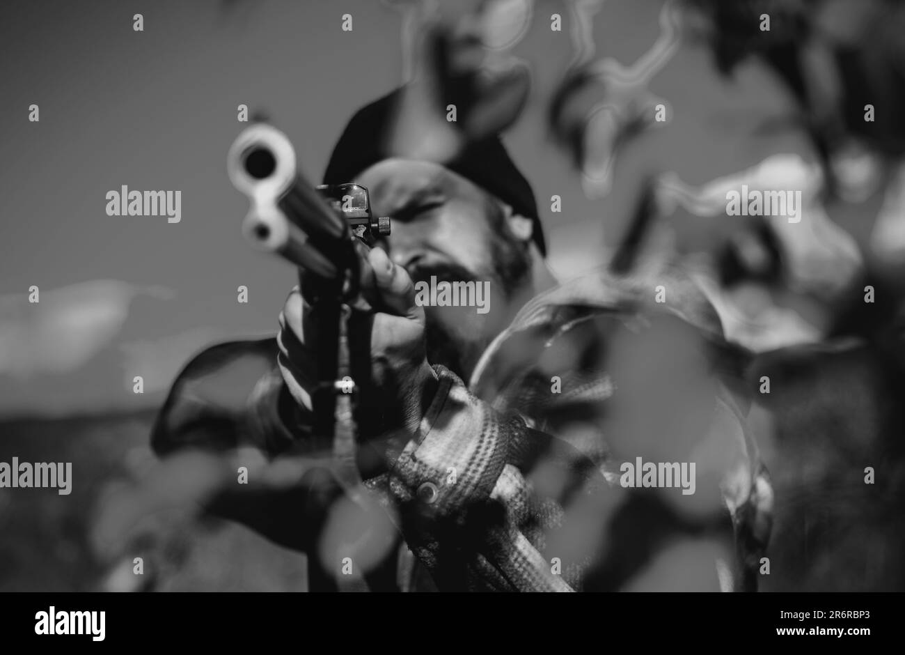 Hunter with shotgun gun on hunt. Hunter aiming rifle in forest. Poacher