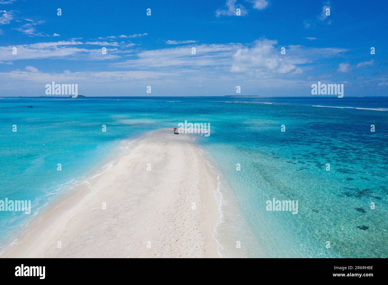 An aerial view of a beautiful beach and crystal-clear blue ocean water