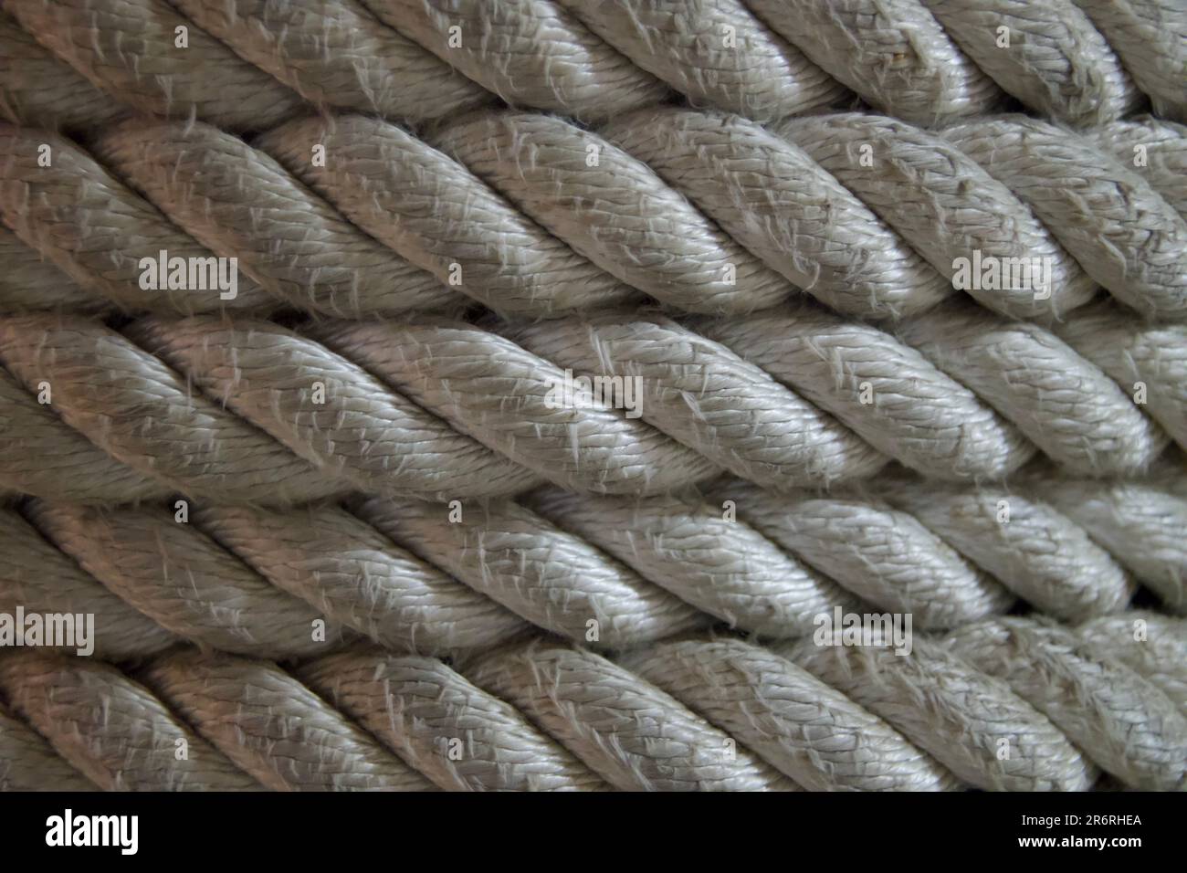 A close-up image of a multi-colored rope featuring various hues of yarn woven together Stock Photo