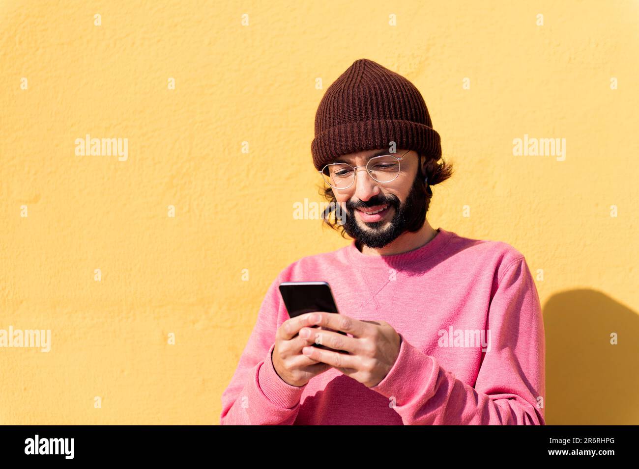 smiling young man using mobile phone Stock Photo