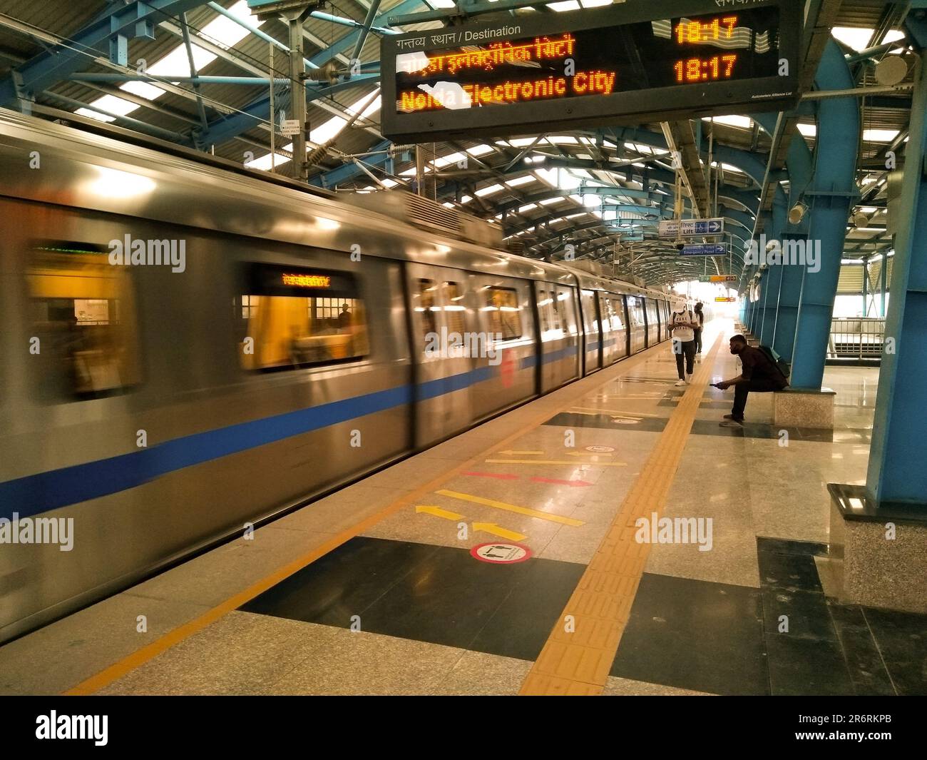 A passenger train at a railway platform in an airport terminal, with
