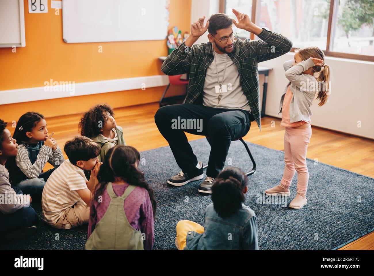 Male educator in a primary school class Teacher shows a little girl Male educator in a primary school class Teacher shows a little girl
