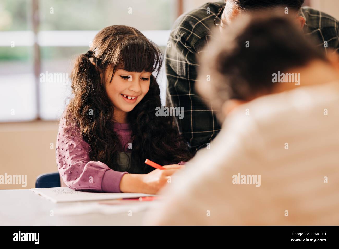 Happy child enjoys being part of a literacy class in elementary school. education, child mentorship and development. Stock Photo