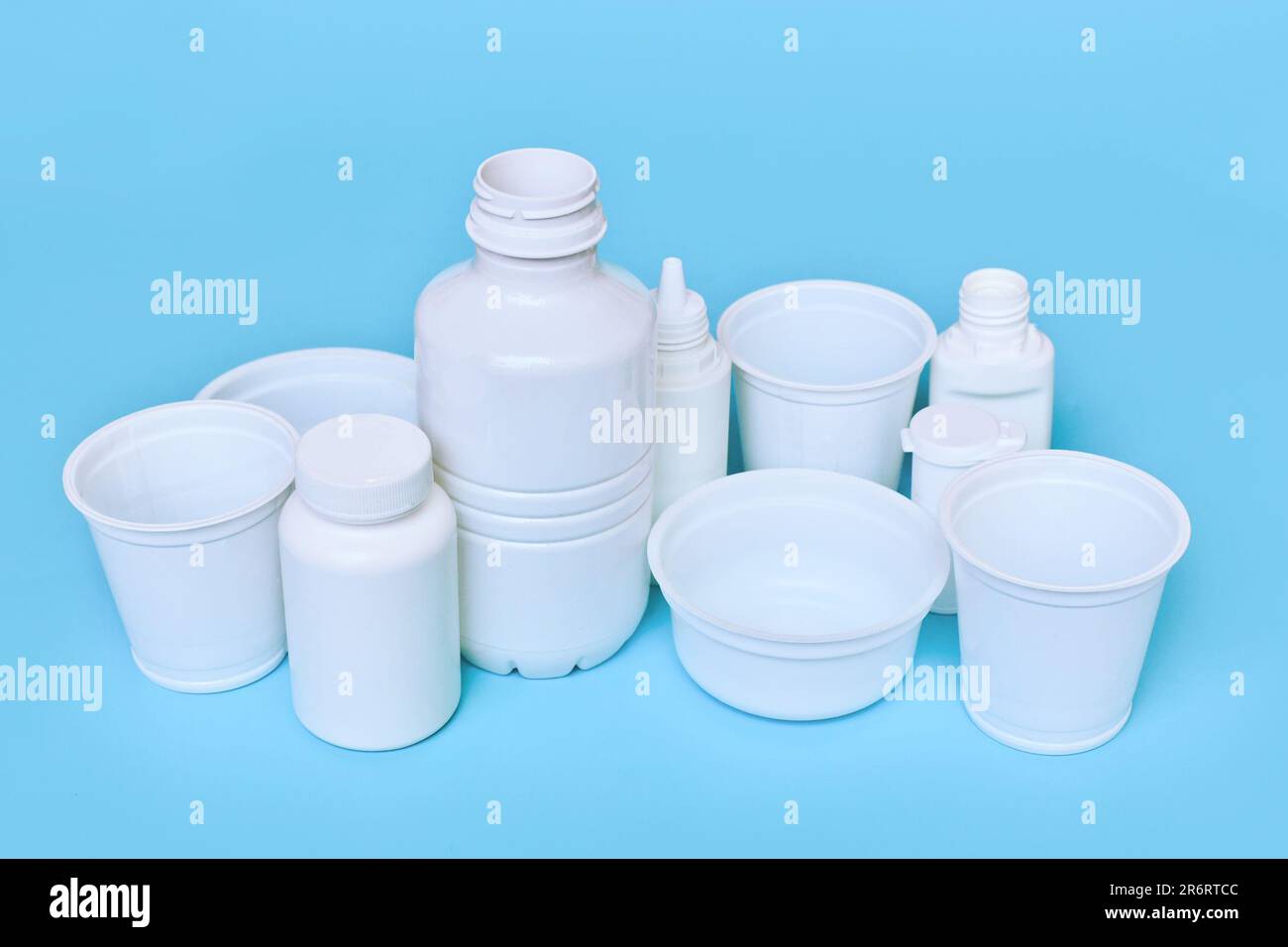 Different plastic waste packages on blue background Stock Photo