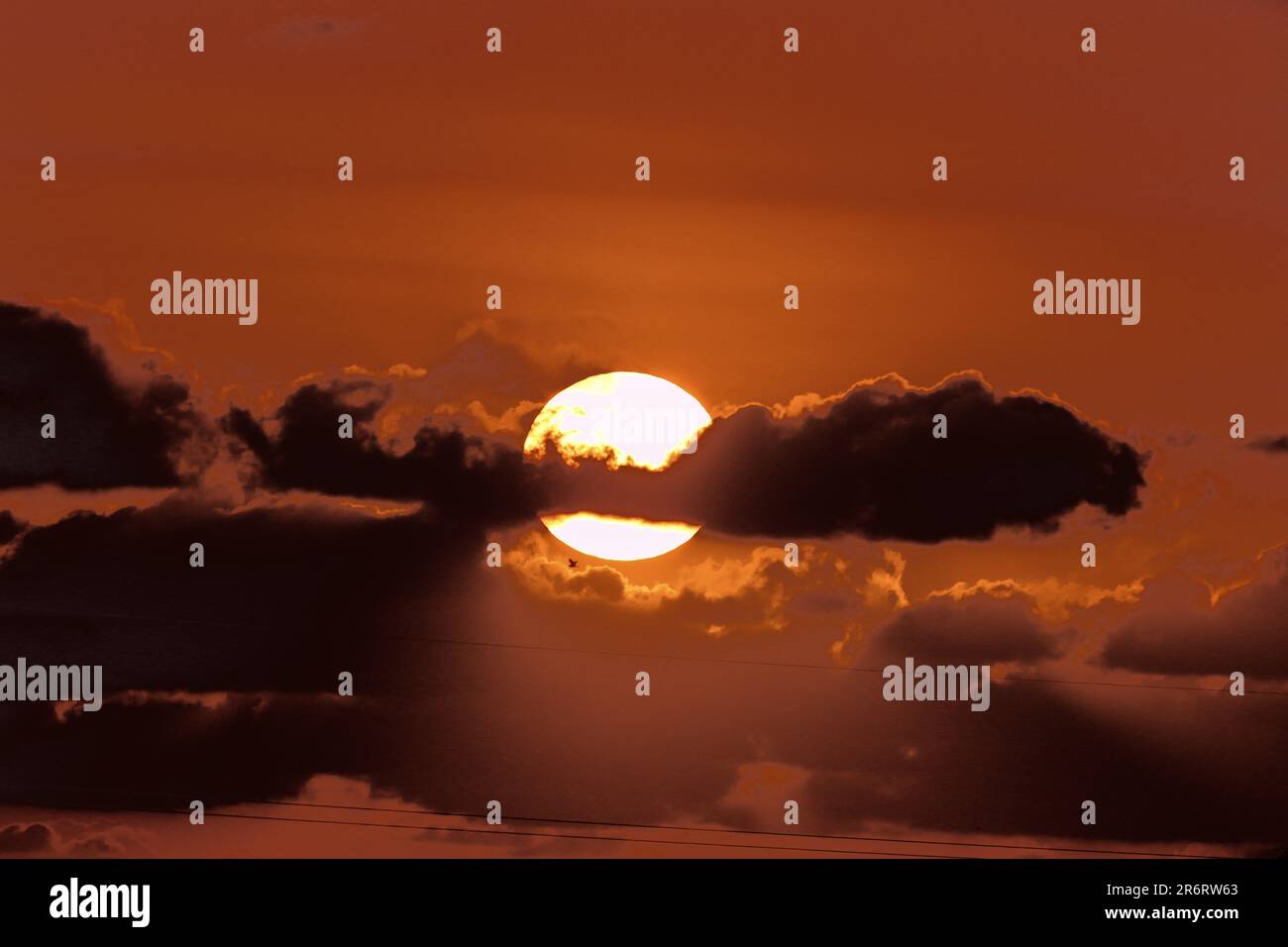 Beautiful sunset scene featuring a backdrop of clouds and a setting sun ...