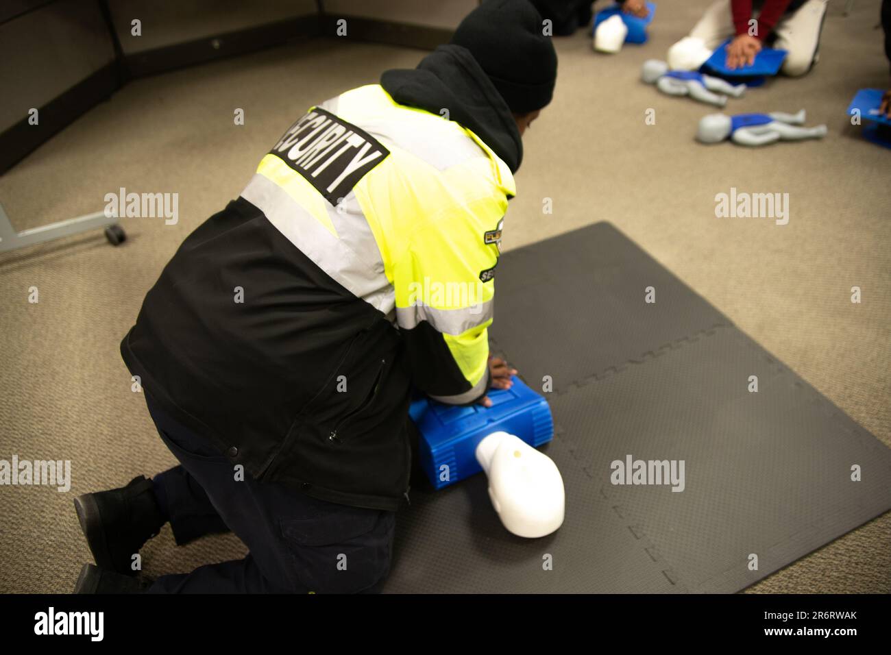 A classroom of students learning the basics of first aid with a doll ...