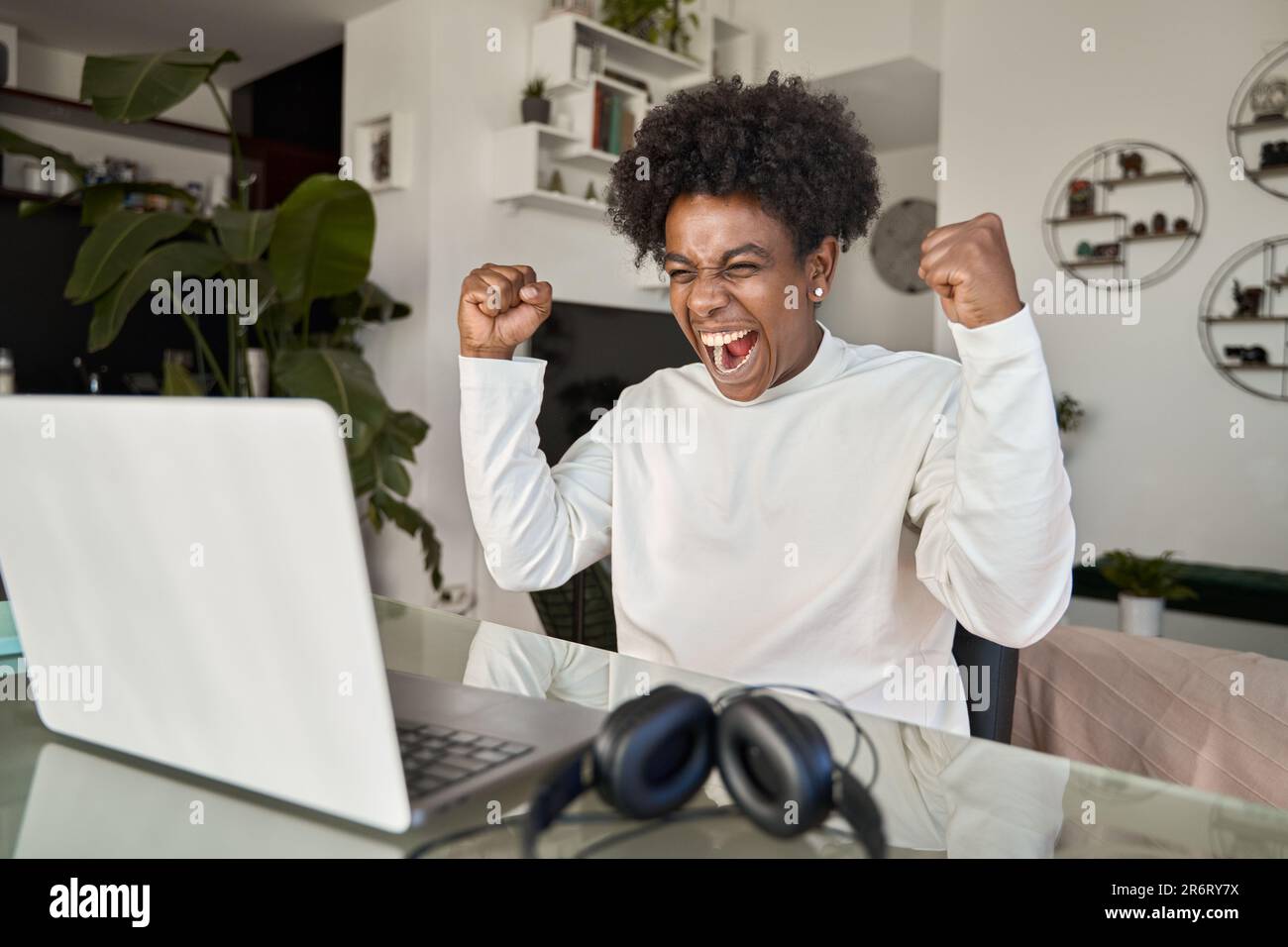Excited African American student celebrating online win looking at ...