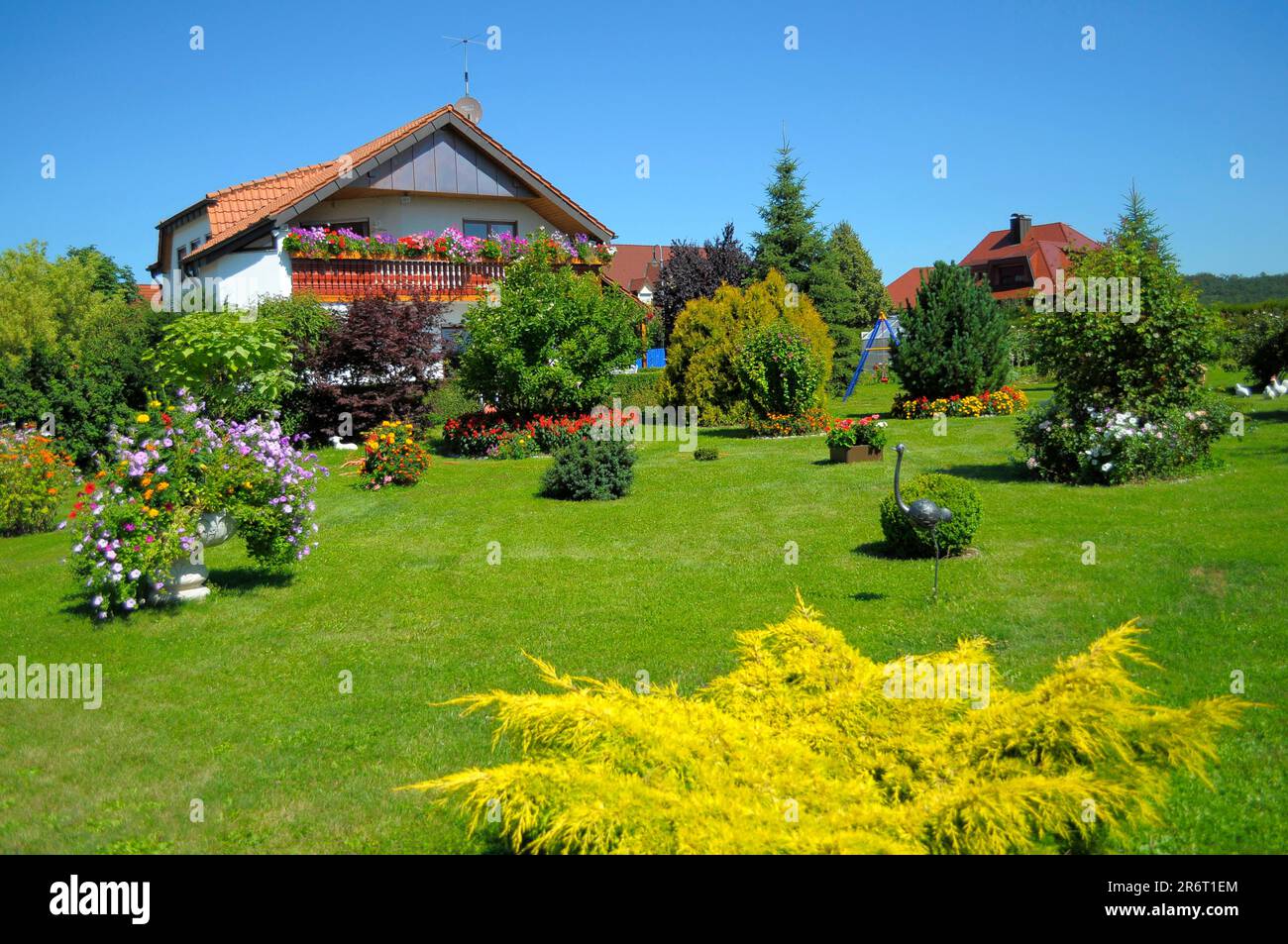 Garden area in summer Residential house in garden, balcony with flowers, ornamental garden Stock Photo