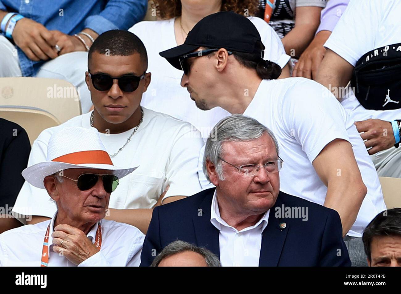 Swedish football player Zlatan Ibrahimovic, top right, speaks to French  football player Kylian Mbappe as they wait for the start of the final match  of the French Open tennis tournament between Serbia's