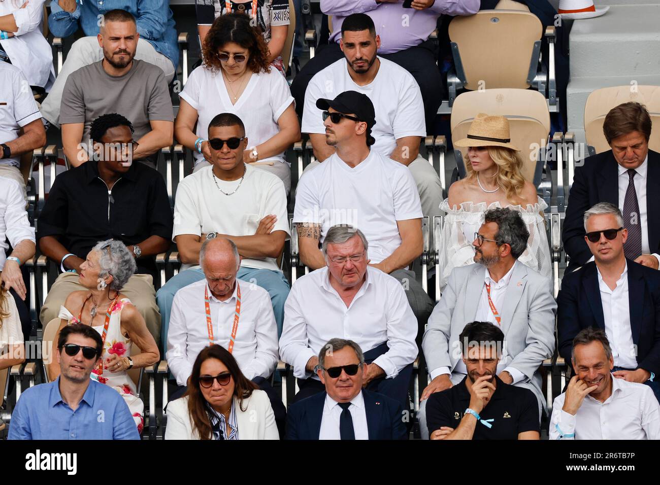 Football players Kylian Mbappe, center left, and Zlatan Ibrahimovic, center right, both wearing sunglasses, watch the final match of the French Open tennis tournament between Serbias Novak Djokovic and Norways Casper Ruud