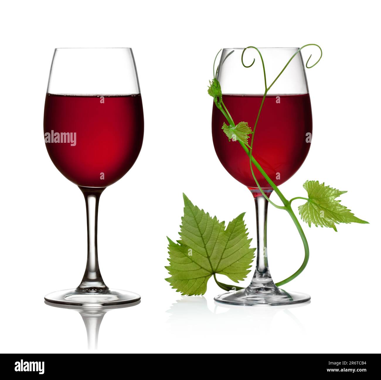 Glass of red wine and grape leaves on a white background and with soft