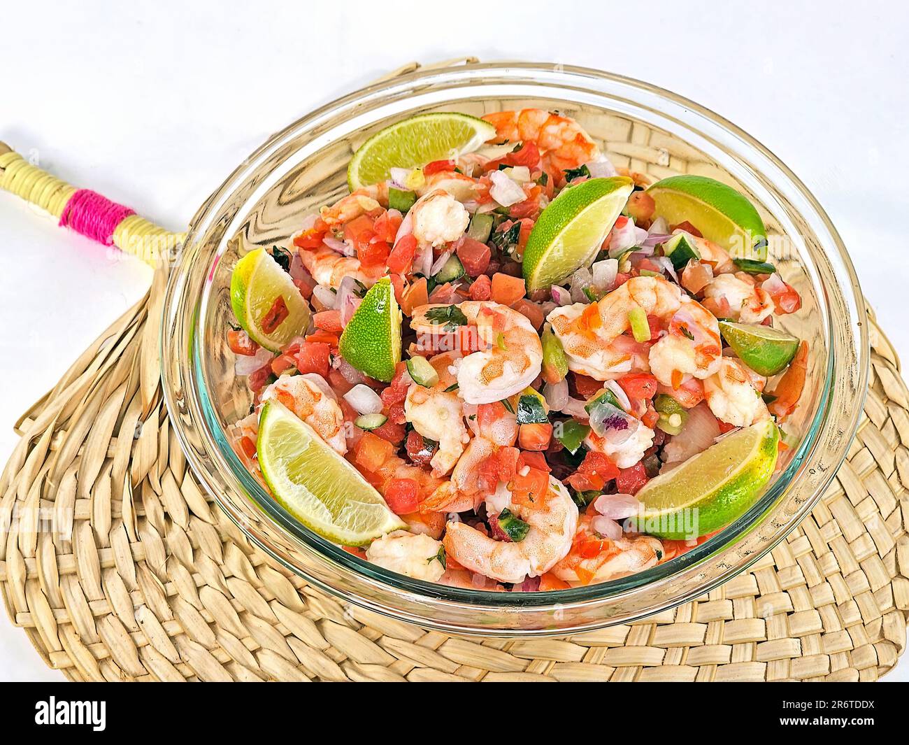 Fresh shrimp salad with lime slices in a glass bowl on a bamboo mat Stock Photo