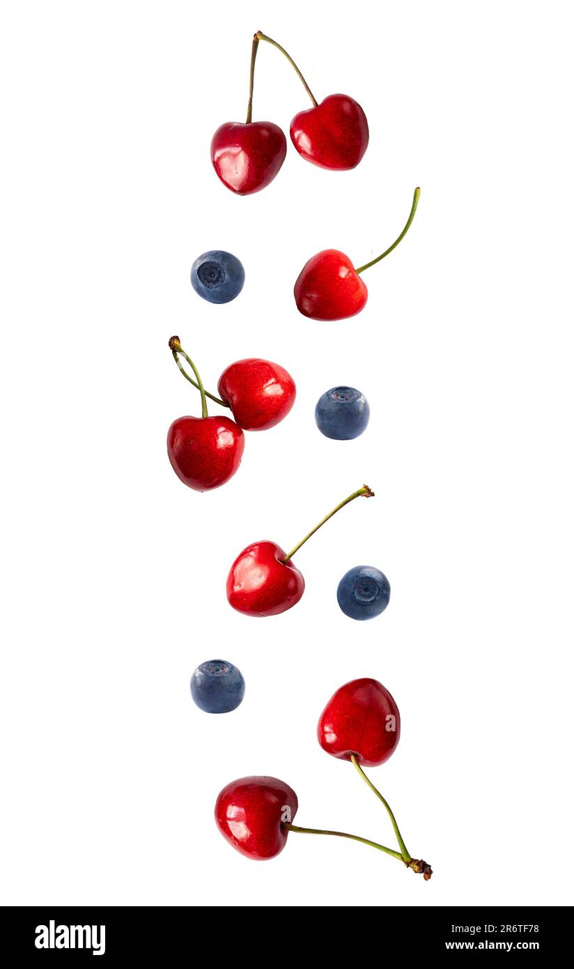 Falling cherry and blueberries isolated on white. Cherry fruit and