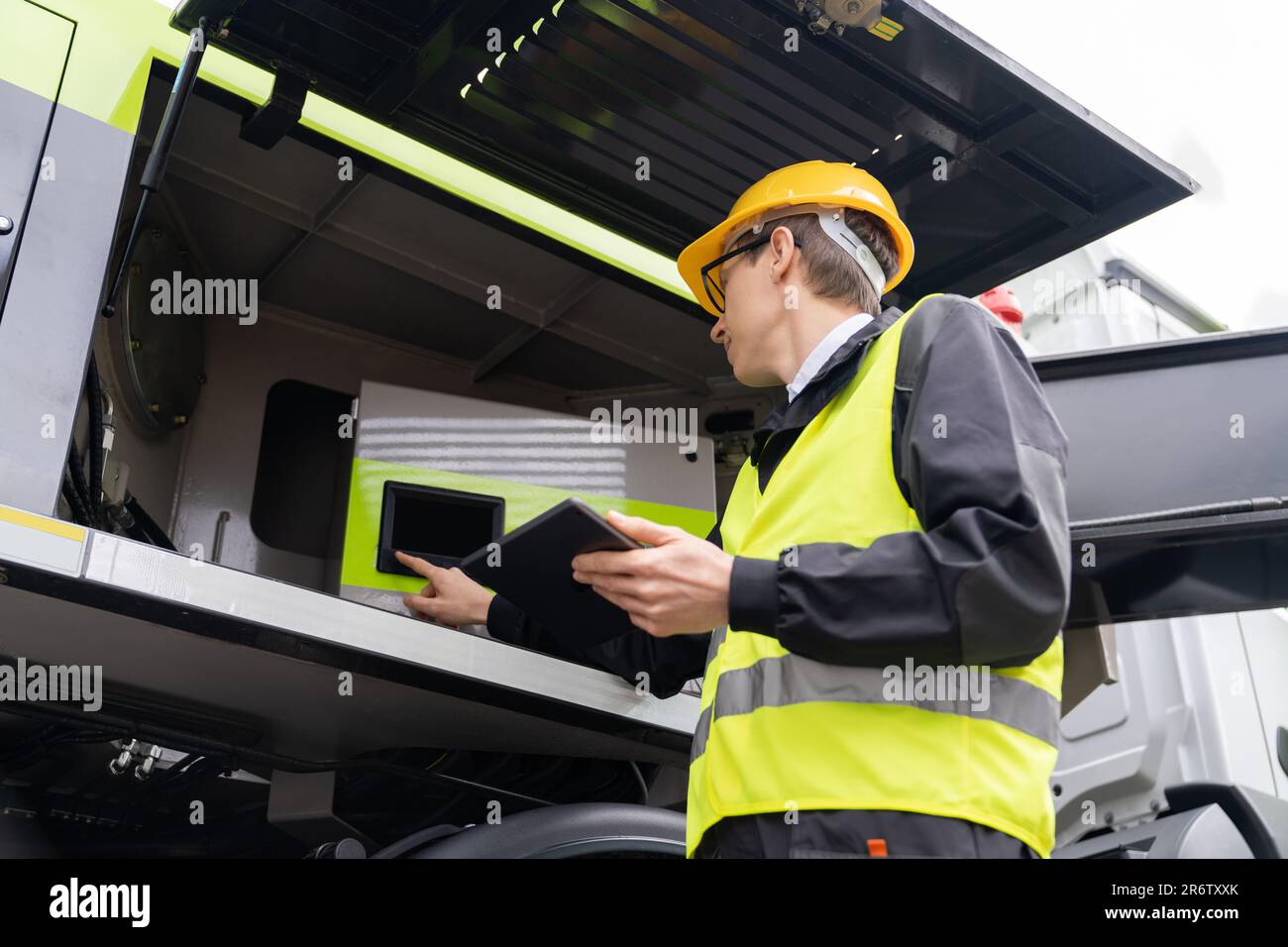 Worker with digital tablet operating construction machine equipment Stock Photo