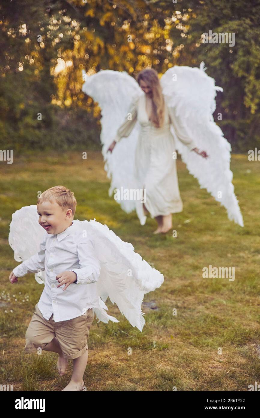 Olstrup, Denmark, June, 2023: Girl angel with her son in the garden Stock Photo