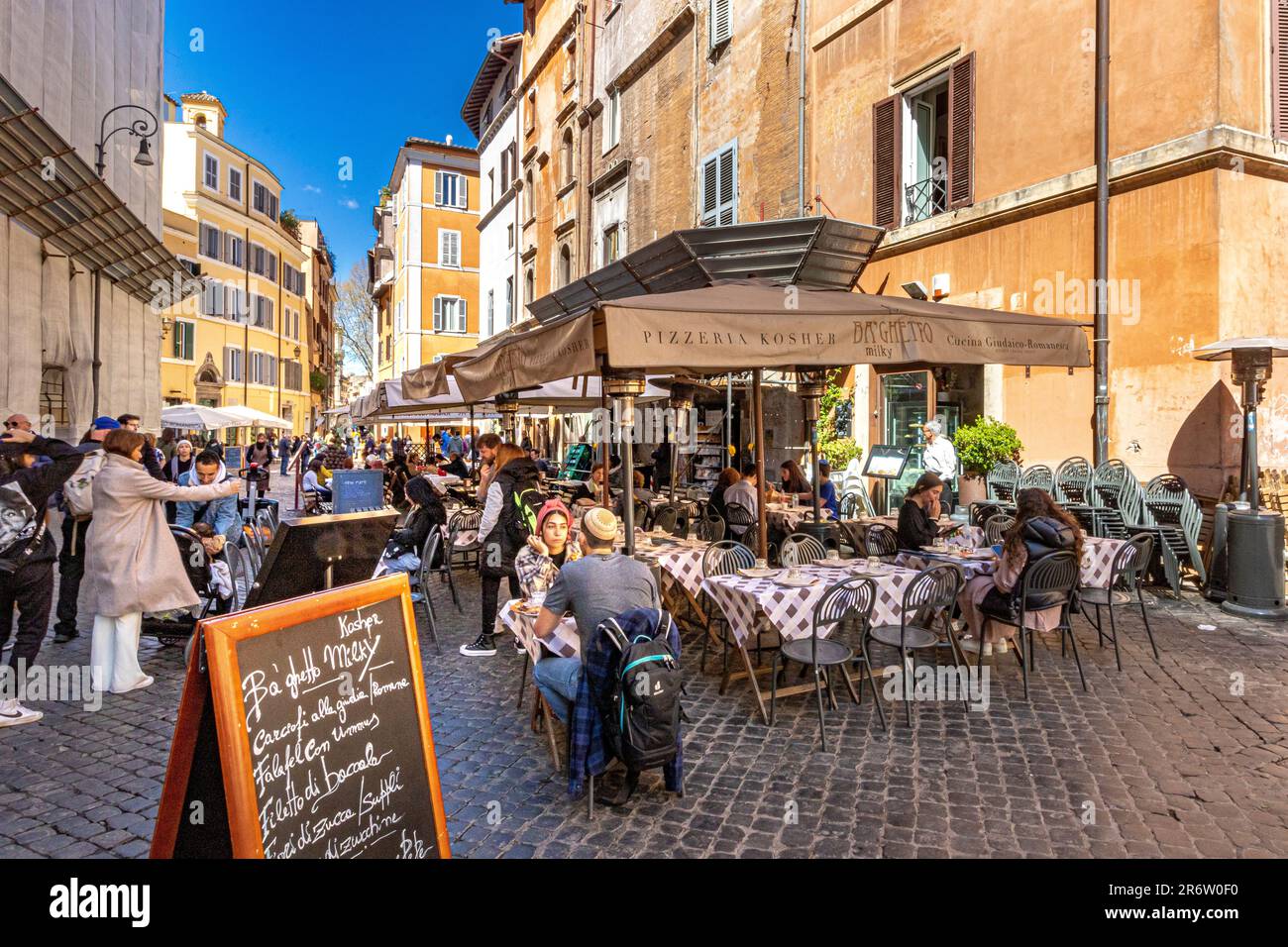People sitting outside a Kosher restaurant on Via del Portico d’Ottavia in Rome's Jewish quarter, Rome Italy Stock Photo
