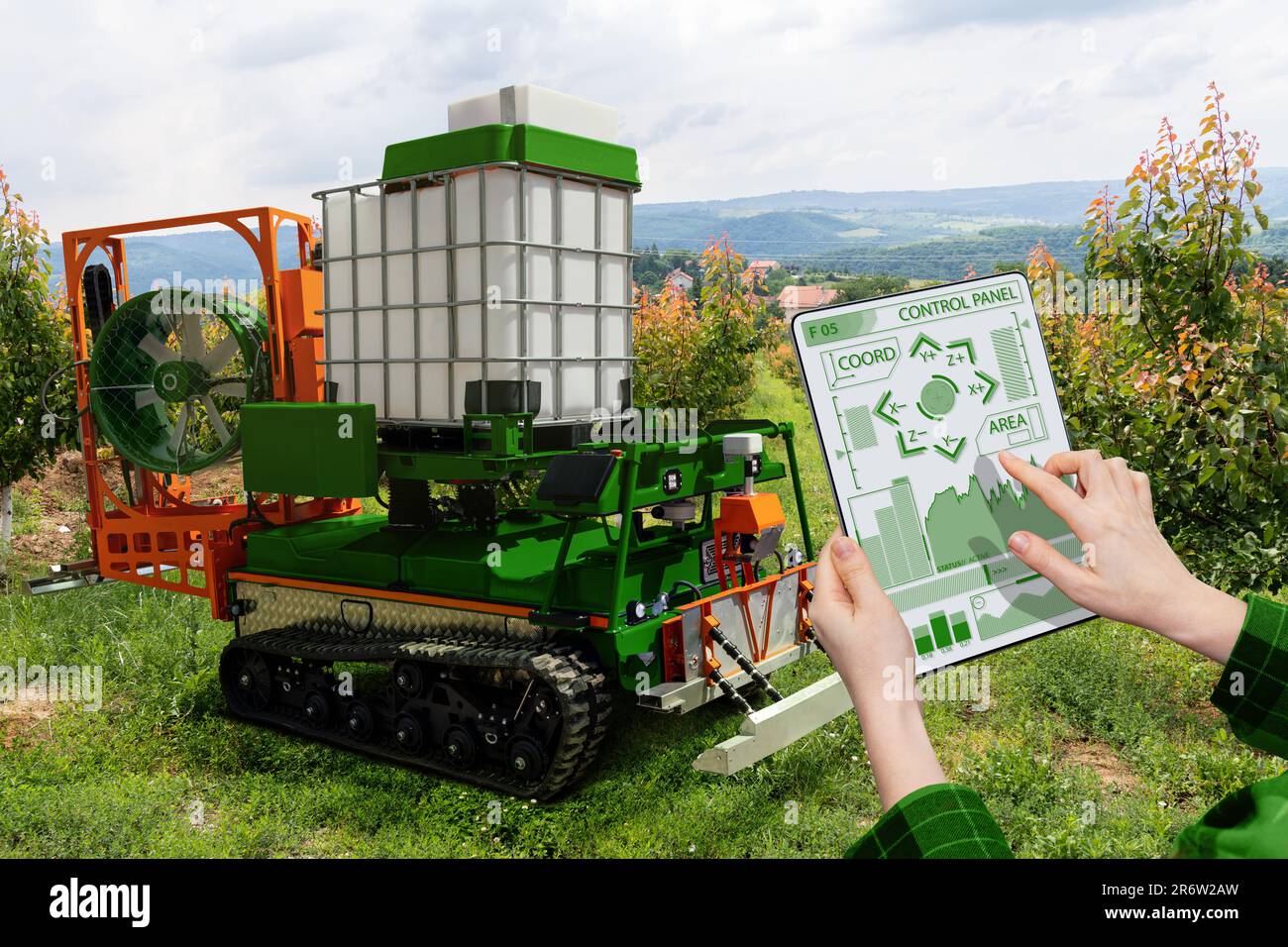 Farmer controls autonomous robot sprayer in a fruit garden. Smart farming concept Stock Photo