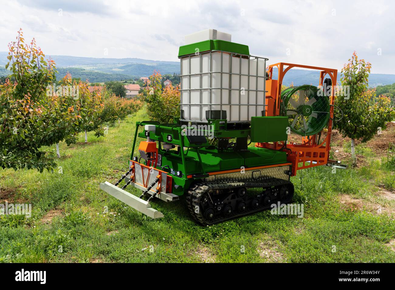 Autonomous robot sprayer works in a fruit garden. Smart farming concept Stock Photo