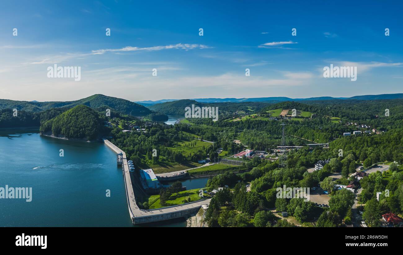 Panoramic view from the drone during sunset, on Lake Solina overlooking the modern gondola lift with a lookout tower over the Solina water dam, in the Stock Photo