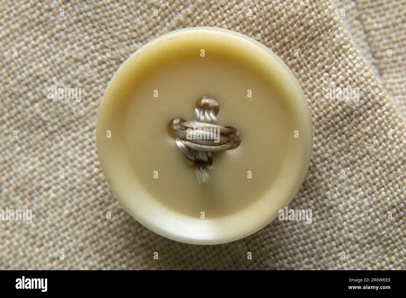 light brown button on a jacket of a male sleeve as a background macro Stock Photo