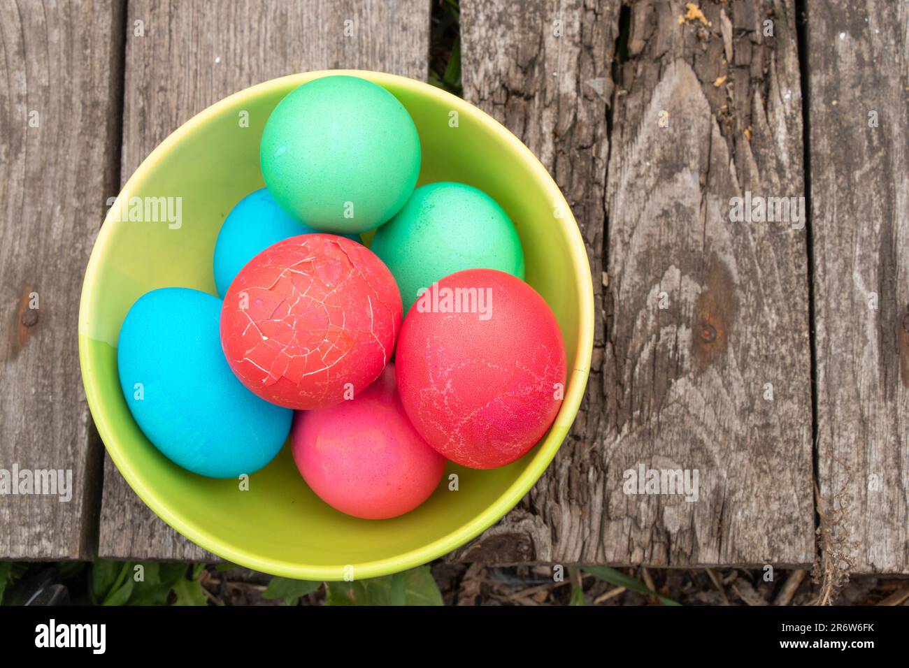 multi-colored easter eggs lie on an old wooden board, on quarantine on Easter Stock Photo