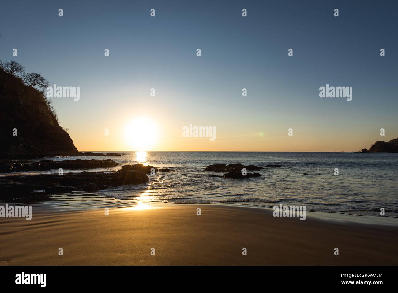 Sunset landscape photo with clear sky overlooking the sandy beach facing the Atlantic ocean in Nicaragua near San Juan del Sur Stock Photo