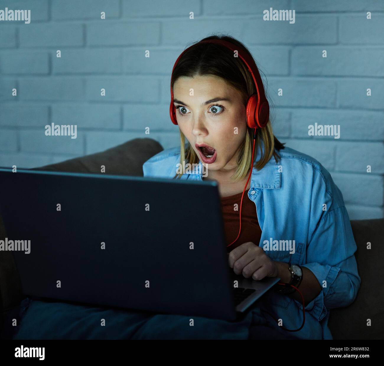 laptop computer headphones movie scared surprised night dark looking girl glowing screen late Stock Photo