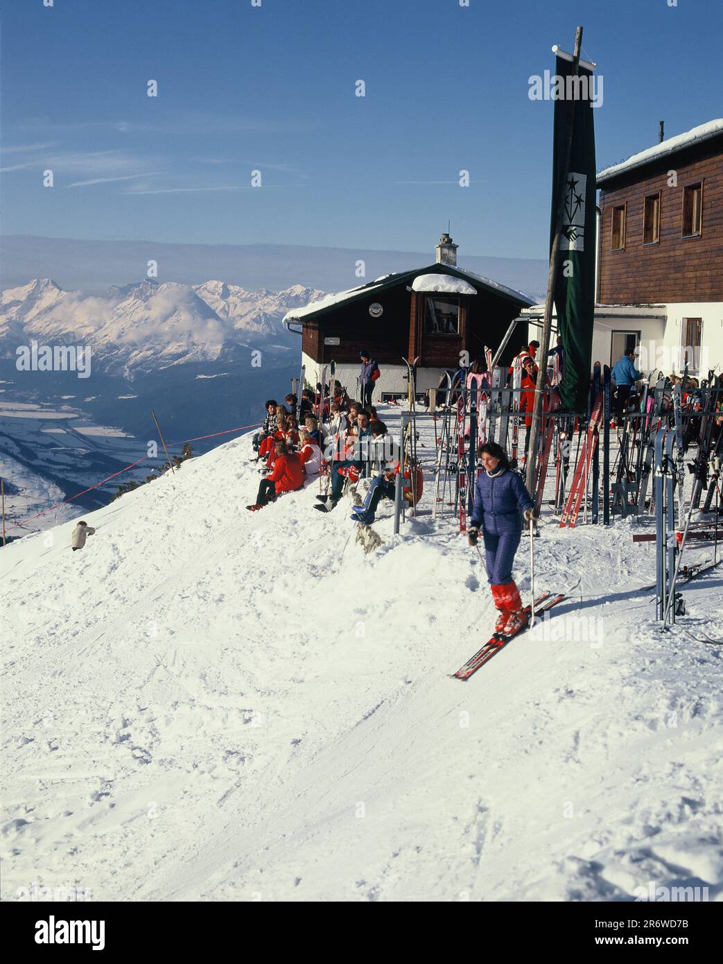 Austria. Innsbruck. Tyrol. Birgitz. Skiers on mountainside resting outside ski huts. Stock Photo