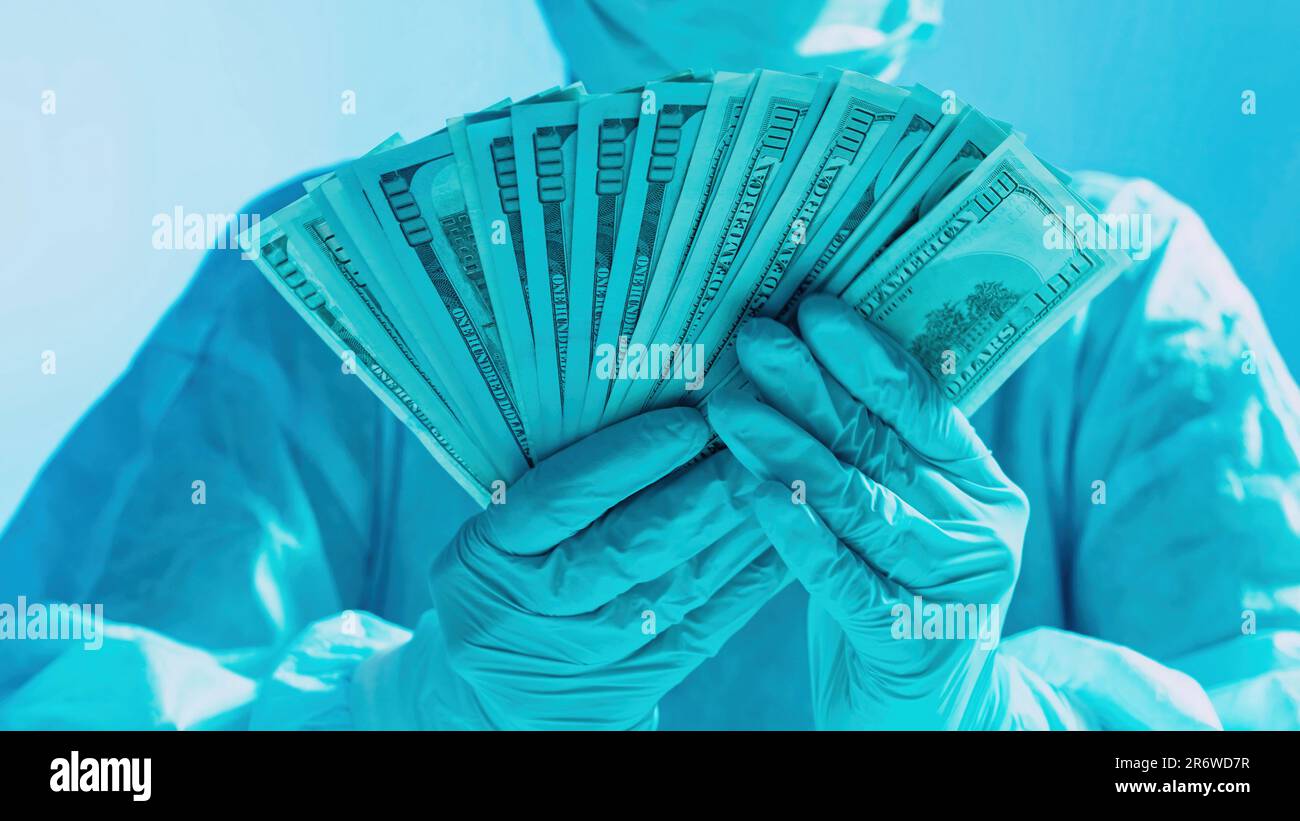 Healthcare costs expenses doctor hands money fan Stock Photo - Alamy