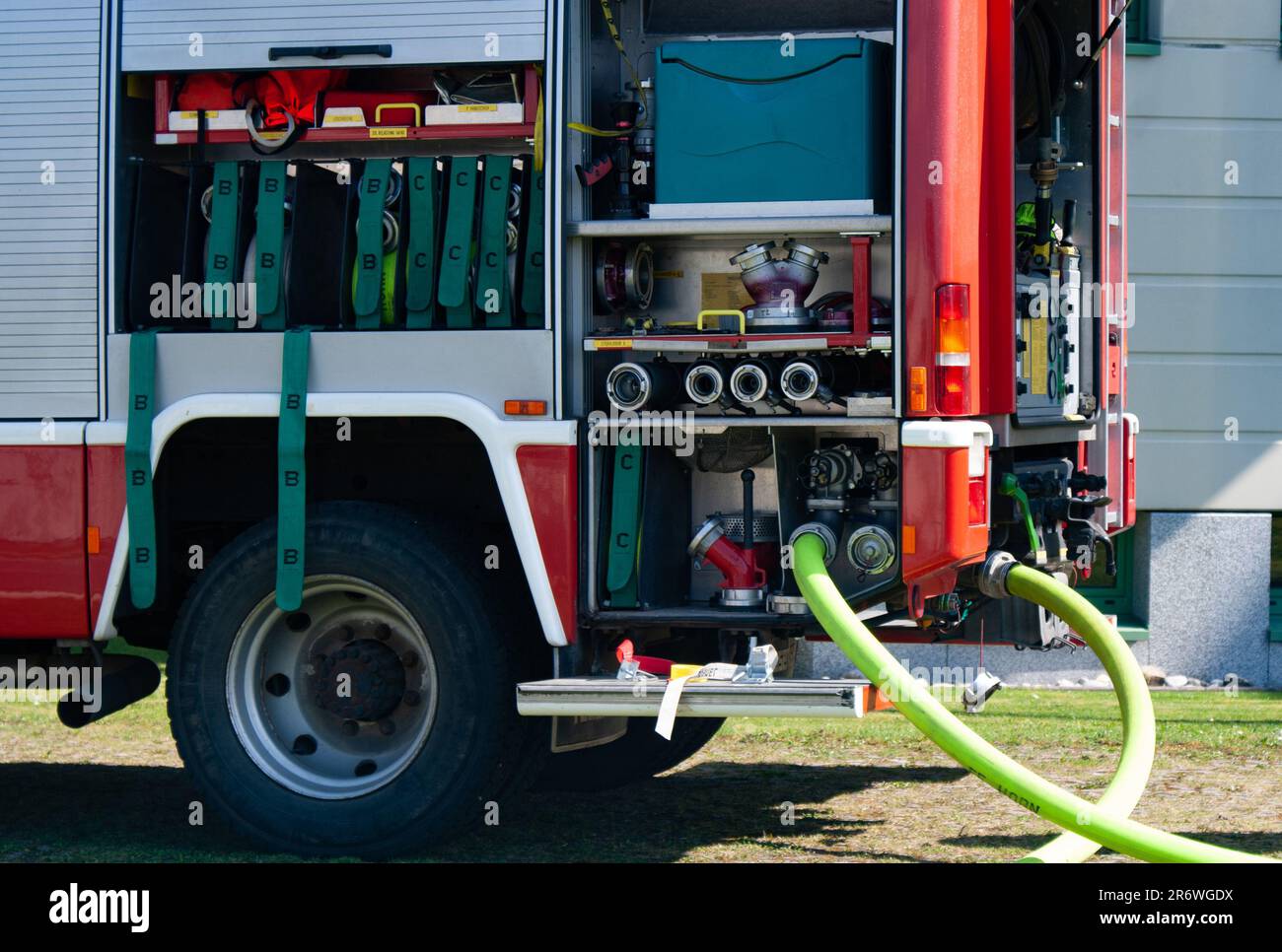 Geräteraum eines Feuerwehrautos mit Schläuchen die Wasser pumpen Stock Photo